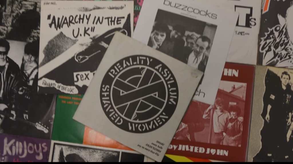 The sleeve of Reality Asylum pictured amongst a collage of other punk single sleeves